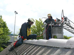 Zwei Feuerwehrleute arbeiten auf einem Spitzach