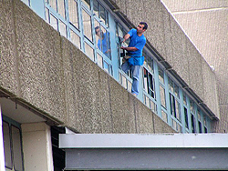 Arbeiter klettert aus einem Gebäudefenster