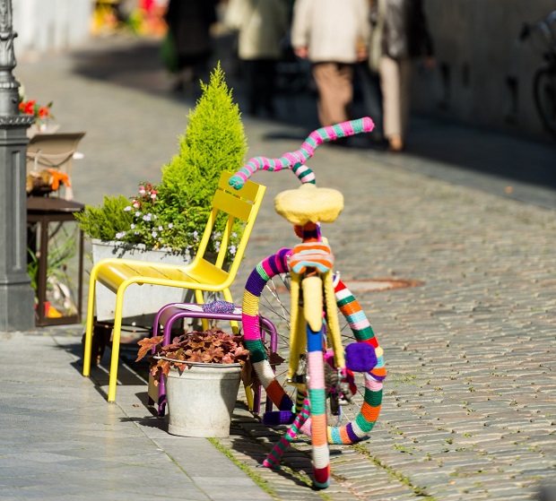 Einkaufsstraße mit Bank, Blumenkübeln und einem bunten Fahrrad